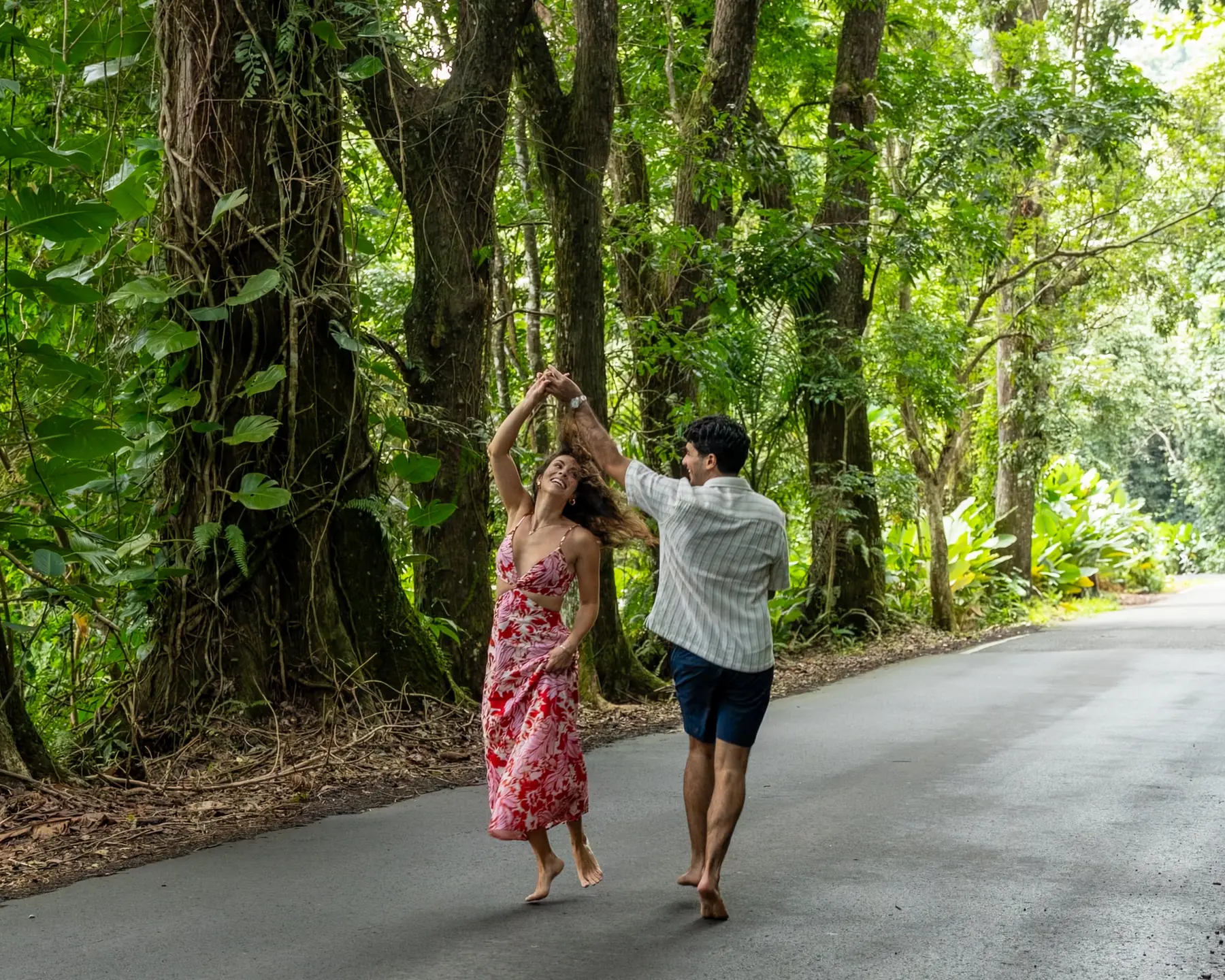 Jacqueline and Vincent dancing barefoot on a road through the rainforest